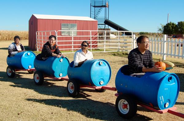 Lab members and Dr. Liu ride in train made out of plastic drums