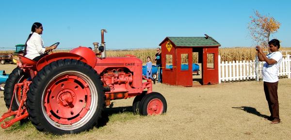 woman rides big red tractor